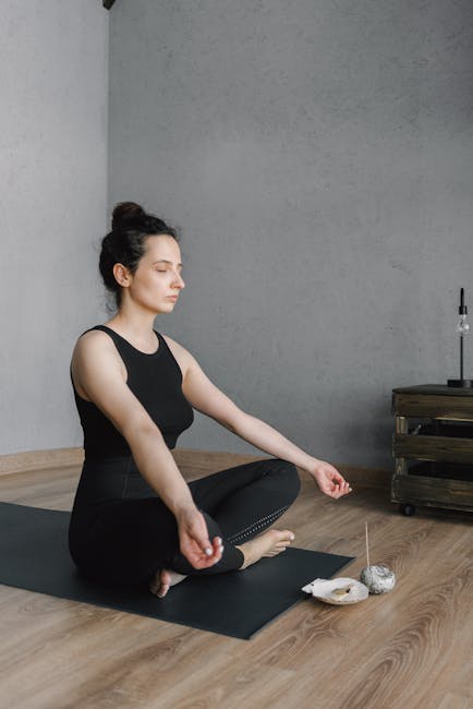 Person sitting comfortably on a yoga mat in a modern living room.
