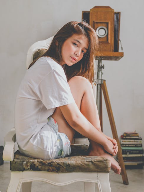 Woman in a comfortable yoga pose looking serene in a softly lit room.